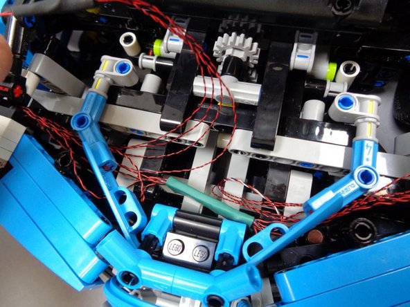 The circuit board with the green covering should sit in the center of the area behind the front grille, as shown in the photos.