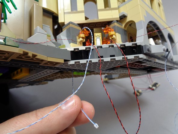 You may find it helpful to prop your castle up on something while you work, as shown in the second photo.  (here we used a camera lens hood, but you can use any similarly-sized object to hold up your castle)