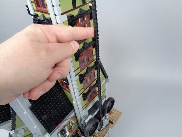 Reconnect the elevator lift chain as shown in the photo for this step.