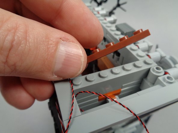 As shown in the first photo for this step, remove the reddish brown 1x6 plate from the right side inner wall of the town hall.