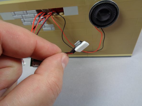 As shown in the three photos for this step, you can use another large sticky square to mount the two volume buttons (volume up/down) to the rear outer cinema wall.