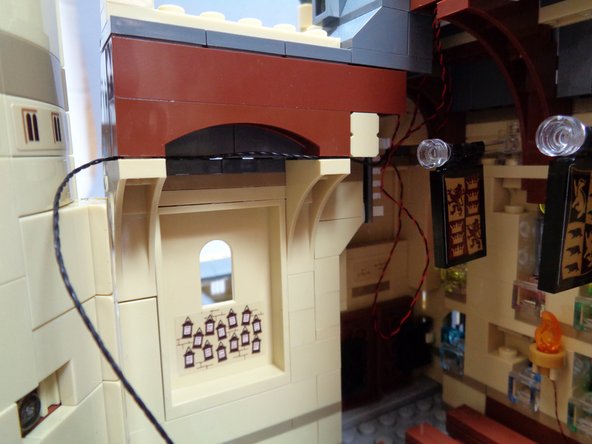 using a LEGO brick separator, carefully separate the side roof section from the tan braces as shown in the second photo.