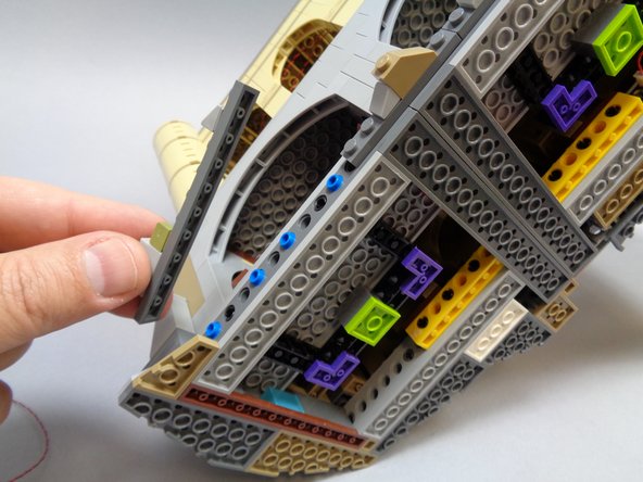 As shown in the first photo, remove the long dark bluish gray plate from the front area below the Room of Requirement.