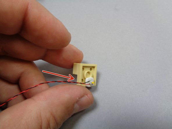 As shown by the red arrow in the third photo, attach the light to the side OPPOSITE the sloped arch assembly.