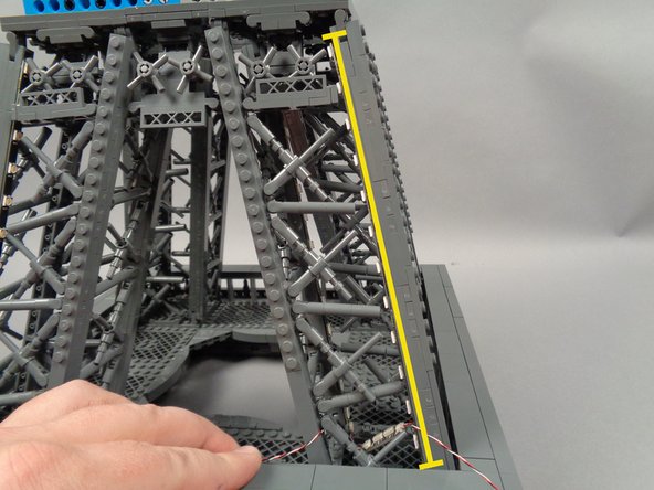 As shown in the photos for this step, attach the next light strip (shown by the yellow line in the second photo) and make sure it is firmly attached to the pillar.