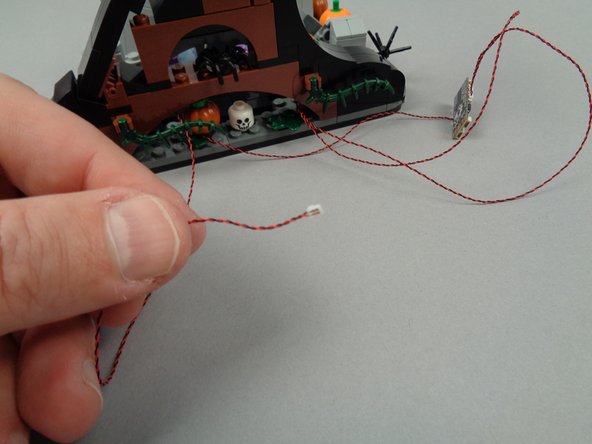 The second photo for this step shows the LED light wire pulled through to the back side.