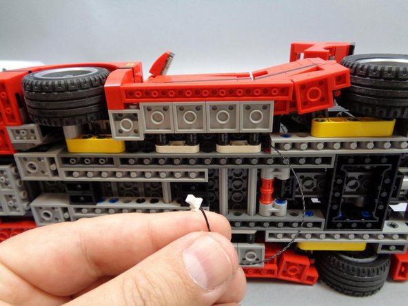 As shown in the second photo, you should now have the black extension cable extending out to the bottom of the car, with enough length to reach up into the back hatch (you will run the cable this way in a later step).