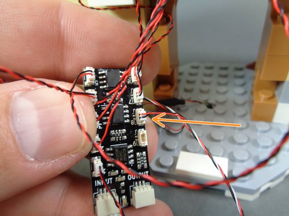 As shown in the second photo, re-attach the light brown stove frame pieces, being careful not to pinch the candelabra light wire.