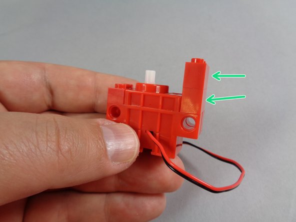 Attach the second red 1x2 LEGO brick on top of the first one, as shown in the third photo for this step.