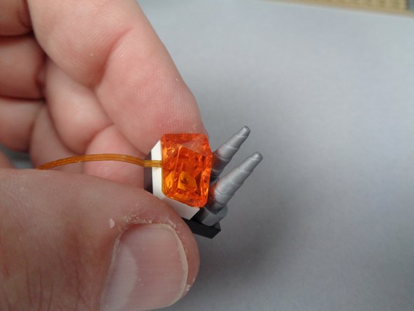 Finish re-assembling the fireplace section by re-attaching the two silver cone/horn pieces and the silver plate underneath them, as shown in the first photo for this step.