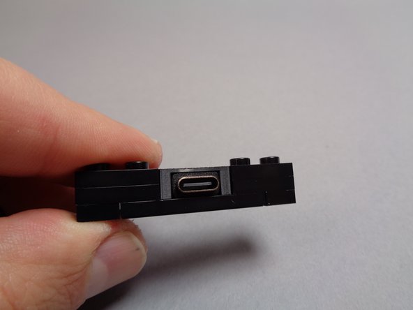 The second photo for this step shows a close-up view of the USB-C power connector bracket, which is made using LEGO parts and a 3D-printed element holding the USB-C plug in place.