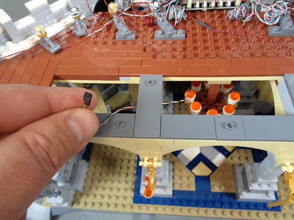 As shown in the photo for this step, you may choose to re-locate the wire with the black plug so it feeds to the side of the left torch.