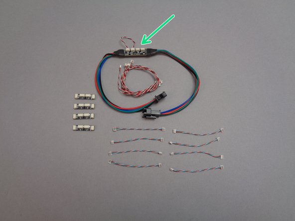 The second photo for this step shows the parts contained in the pink bag inside Box 2.  Most of the parts are the same as those you saw in Box 1, with the exception of the inter-level connecting board shown by the green arrow.