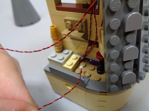 As shown in the second and third photos, route the light wire through the same gap in the floor as the three rooftop tower lights.