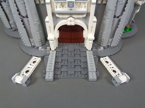 As shown in the photos for this step, next you will remove sections from the front of the castle and the rockwork by the front door.  This is to prepare for re-attaching the two front torches and hiding their wires.