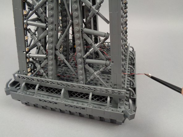 As shown in the third photo for this step, pull the end of the control cable out through the pillar.