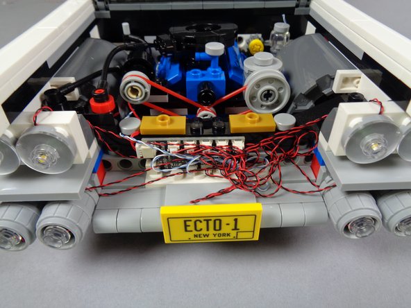 As shown in the photo for this step, coil up any excess headlight wires to take up any slack.