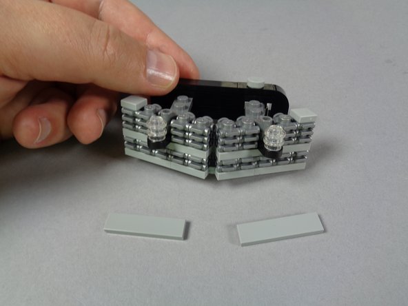 As shown in the photos for this step, free up the assembly that holds the two front strobe lights by removing the two top tiles, then pressing up on the two strobes.  The assembly should come free, as shown in the third photo.