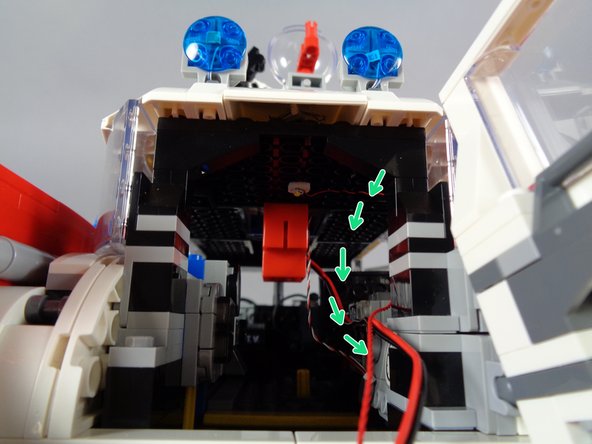 Because there are other wires already passing here, you may need to use a toothpick to gently press the lightbar wire through the hole and down into the inside of the Ecto-1.
