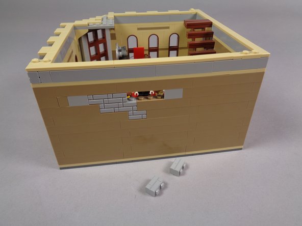 As shown in the second and third photos, remove two of the light bluish gray bricks from the area behind where the cinema frame was mounted.  This will leave a hole in the wall for running the wires from the video player.