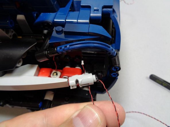 Note that on the side of the car with the wire extending downward from the &quot;blaster&quot; assembly, you will need to run the wire back up behind the &quot;blaster&quot; as shown in the second photo.