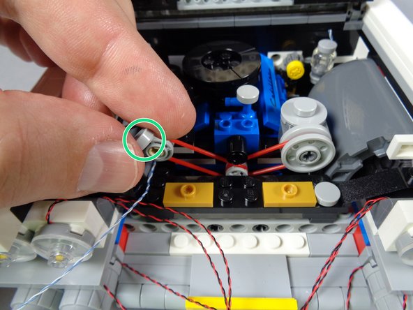 As shown in the second photo for this step, remove the round light bluish gray tile (green circle) from the plate at the front of the engine.