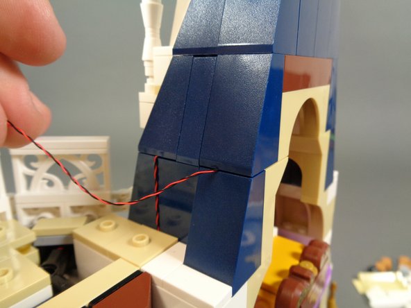 As shown in the third photo, re-attach the blue roof slope piece.