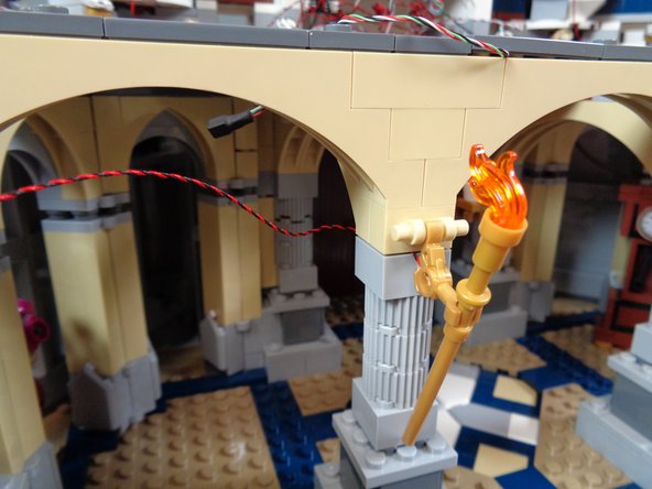 As shown in the first photo, carefully re-attach the pillar behind the torch.