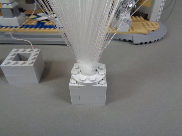 As shown in the first and second photos for this step, insert the end of each spray into a cube and press down on the round plates to hold the sprays in place.