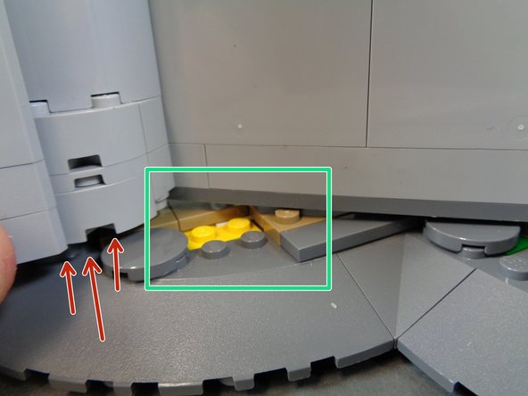 As shown by the red arrows in the second photo, gently lift the castle wall so it will pass over the studs in the floor pieces.