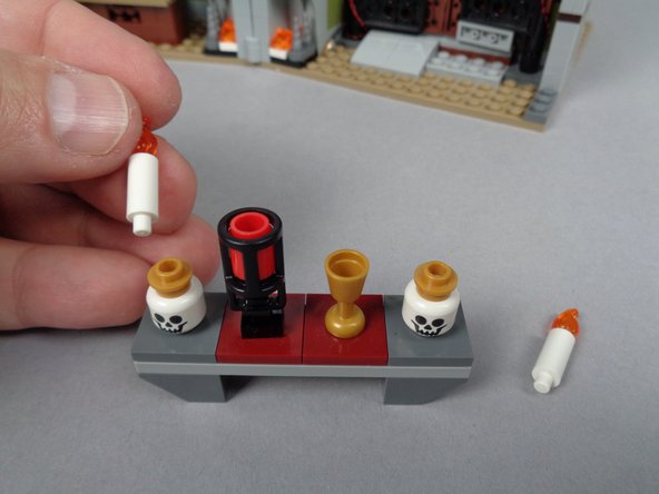 As shown in the two photos for this step, remove the table assembly from the attic, then remove the two un-lit candles.