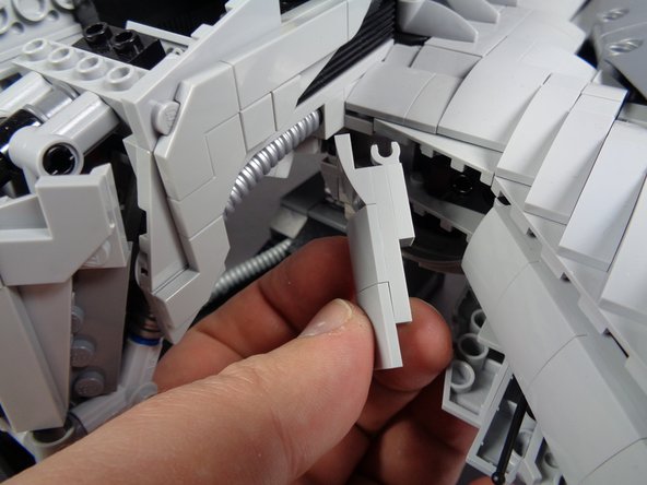 As shown in the first photo for this step, remove the front armor section to the right of the head section.