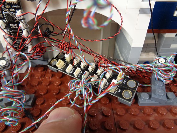 As shown in the photos for this step, your fireworks connect to the rest of your castle lights by means of the BRANCH17 adapter mounted behind the light strip in the castle midsection.