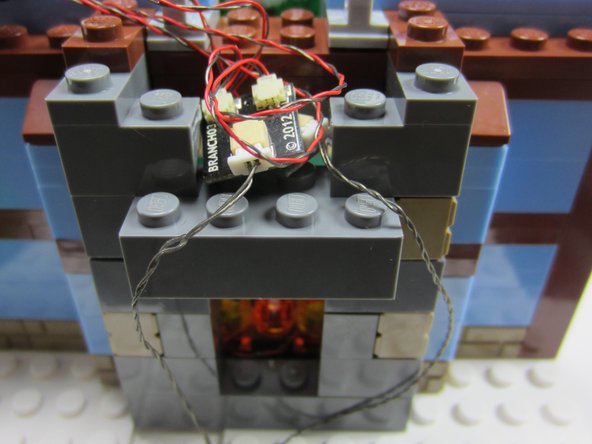 Carefully remove the tall part of the chimney, along with the back of the fireplace, mount the A3 boards loosely in the top of the fireplace, and carefully run the two connecting cables down through the gap in the baseplate at the base of the fireplace.