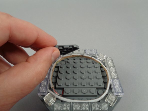 Begin re-assembling the broadcast tower by replacing the triangle/corner LEGO plates as shown in the photos for this step.