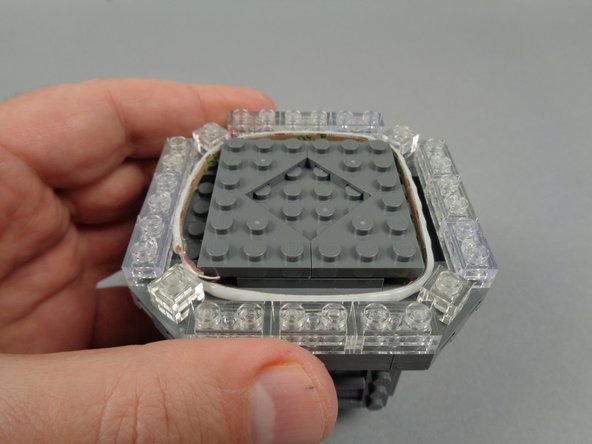 Begin re-assembling the broadcast tower by replacing the triangle/corner LEGO plates as shown in the photos for this step.