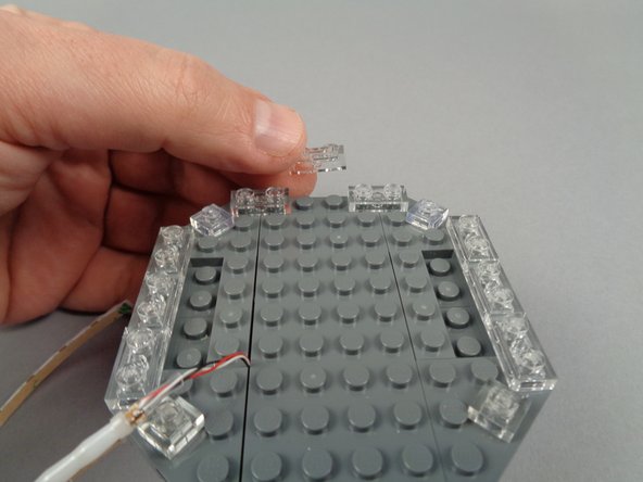 As shown in the photos for this step, re-attach the clear 1x2 LEGO plates you removed earlier.