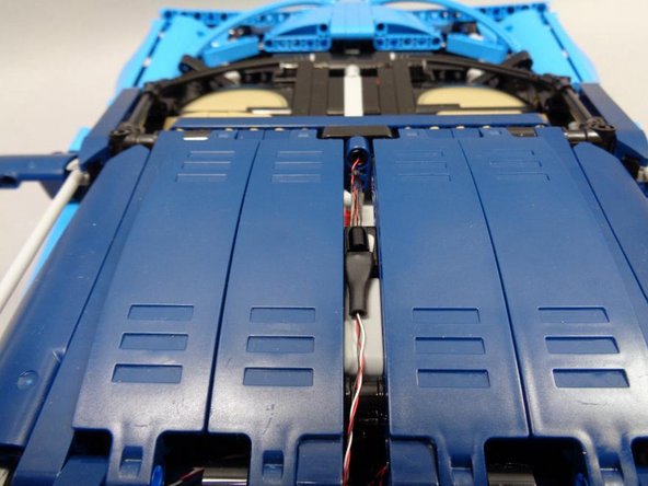 If you will be using an AA battery pack to power your model, do not attach any wires or adapter boards using sticky squares, as the battery pack needs to be able to slide into the space in front of the engine (on the flat panel under the roof).  The next step discusses how to mount the battery pack.