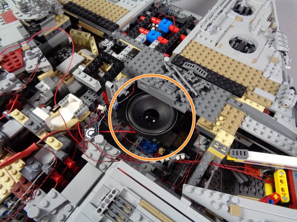 The orange circle in the first photo for this step shows the recommended location to mount the new laser sound speaker.