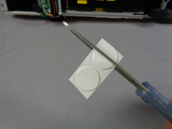 Using a pair of scissors, cut one of the large glue discs into four pieces as shown in the third photo for this step.