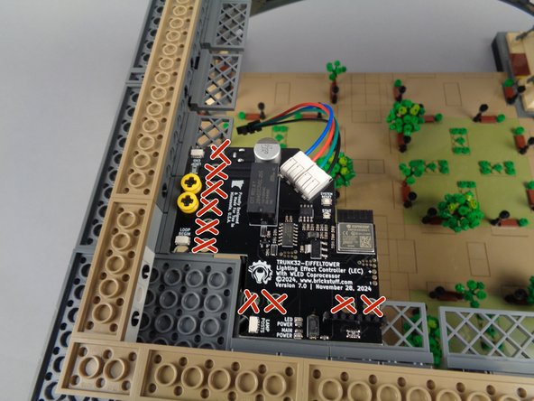 As shown in the second photo, press one of the axle pieces down through the hole in the main controller and through the opening in the LEGO fence piece in the tower frame below the controller.