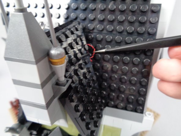 Keep the number of wires passing between the two dark tan plates as small as possible.  It's ok to have a few wires passing between these plates (as shown in the first photo for this step), but no wires with black tubing sections should sit between the plates.