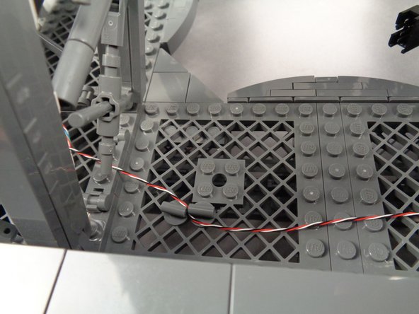 Pass the wire between the pieces, and rotate so they are parallel to hold the wire in place.