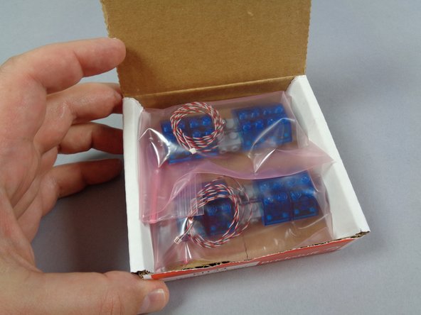 As shown in the photos for this step, open the box with the two pre-assembled lightbars inside.