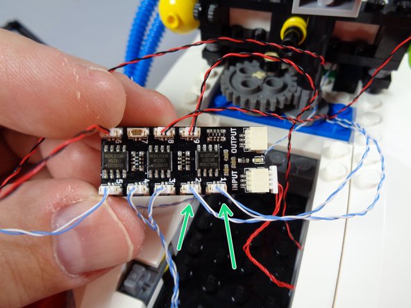 As shown in the first photo for this step, you should have three wires coming from the front of the Ecto-1 roof all the way to the back: two blue/white wires and one red/black wire.