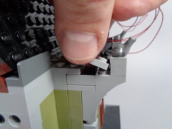 As shown by the green rectangle in the first photo for this step, make sure all light wires pass BEHIND the wall pieces you are re-assembling.  The parts should not pinch any wires as you re-attach them.