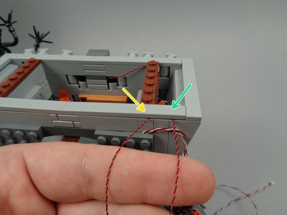 As shown in the second photo for this step, route the wires for the banner light and the right torch between studs, and re-attach the tile.