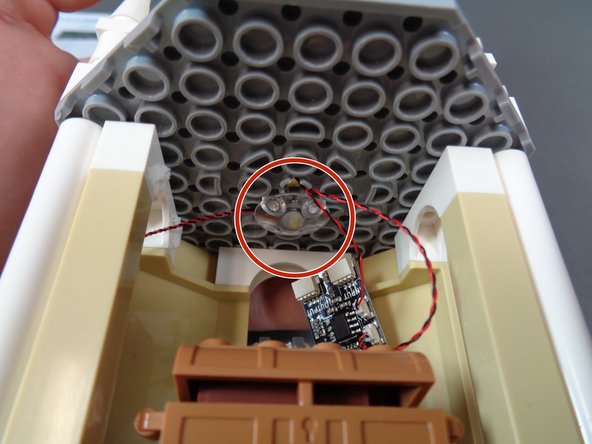 As shown by the red circle in the second photo, use another clear &quot;boat stud&quot; piece to hold the light in place on the ceiling, just next to the hole where the two wires pass through.