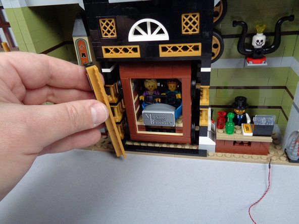 As shown in the three photos for this step, remove the two side brackets holding the elevator in place, then carefully remove the elevator car.  Set aside.