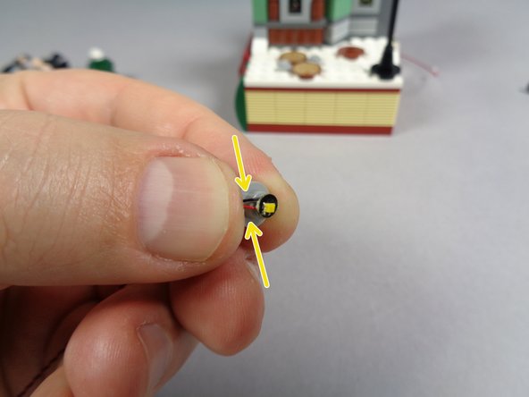 Take the LED light from the &quot;Yellow Lights&quot; Bag and place it on top of the stud of the round 1x1 plate as shown in the second photo.